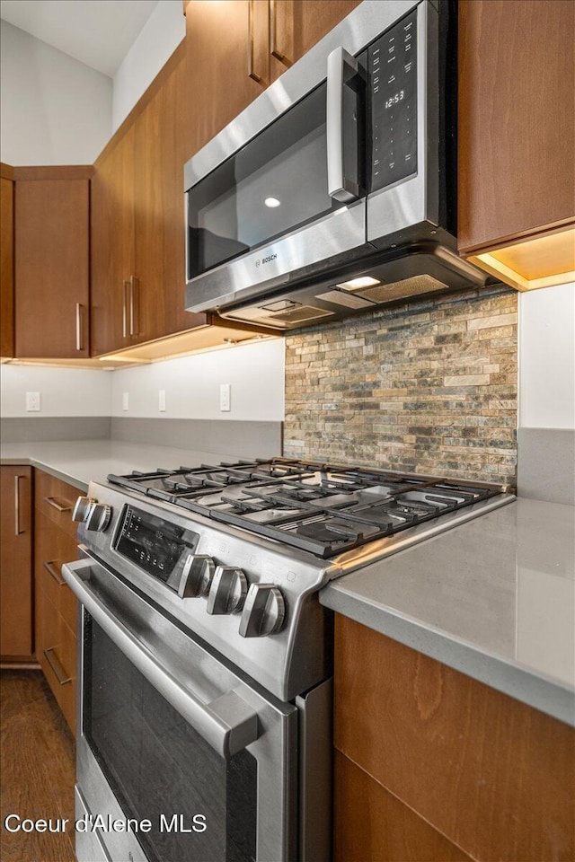 kitchen featuring dark hardwood / wood-style floors, stainless steel appliances, and backsplash