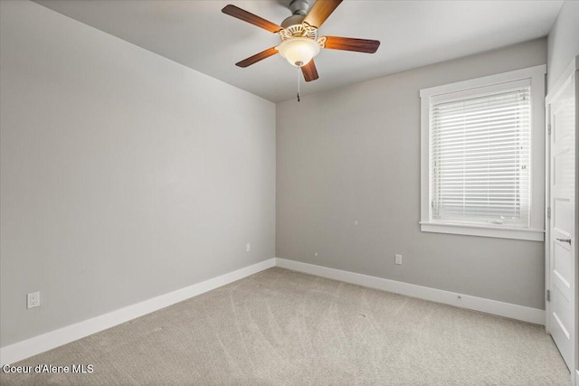 carpeted spare room with ceiling fan