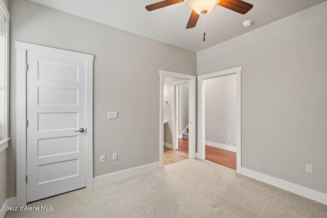 unfurnished bedroom with ceiling fan and light colored carpet