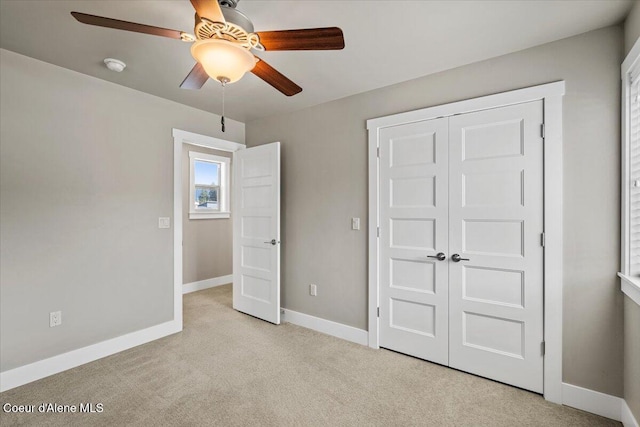 unfurnished bedroom with ceiling fan, a closet, and light carpet