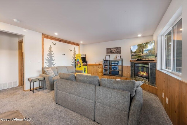 living room featuring a tiled fireplace and carpet floors