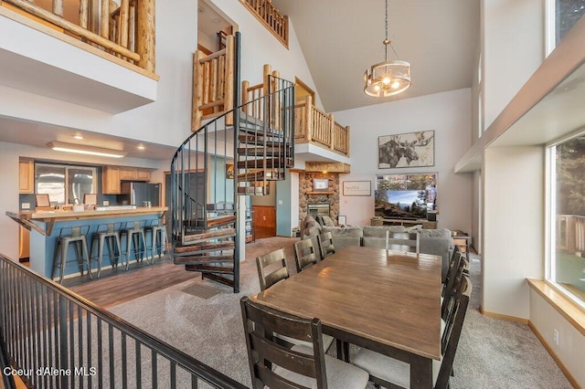 carpeted dining space with a notable chandelier and a towering ceiling