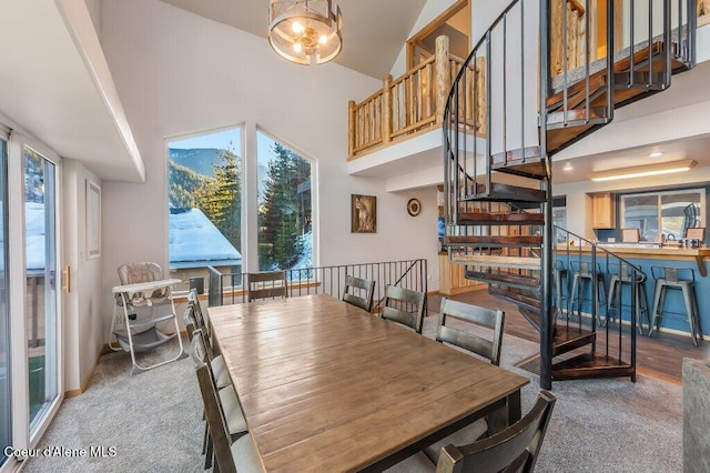 dining area featuring carpet floors and high vaulted ceiling