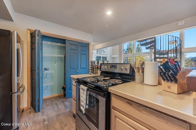 kitchen featuring wood-type flooring, light brown cabinets, and appliances with stainless steel finishes