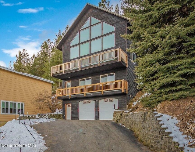 back of property with a balcony and a garage