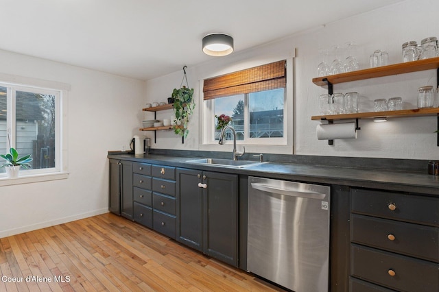 kitchen with stainless steel dishwasher, sink, and light hardwood / wood-style floors