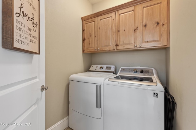 laundry room featuring cabinets and separate washer and dryer