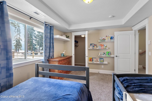 bedroom with carpet floors and a tray ceiling