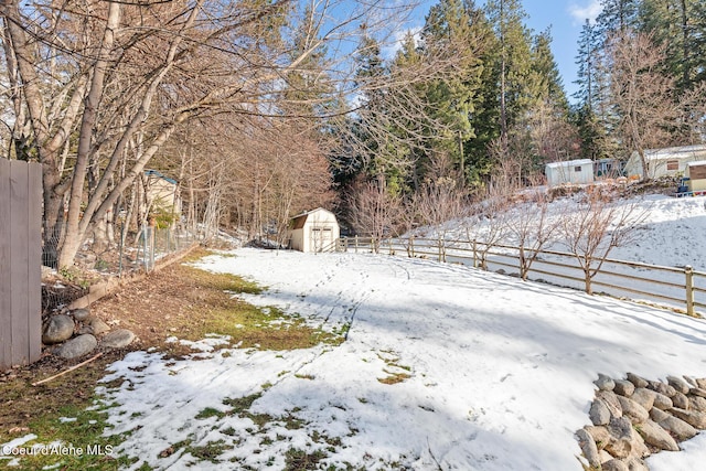 yard covered in snow with a shed