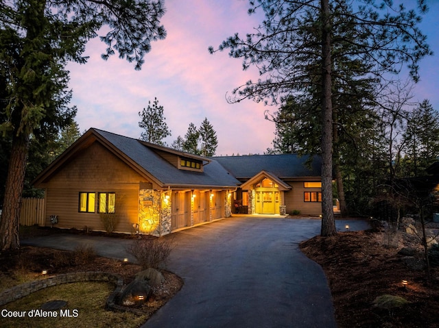 rustic home with fence and aphalt driveway