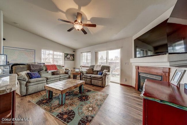 living room featuring ceiling fan, hardwood / wood-style floors, and vaulted ceiling