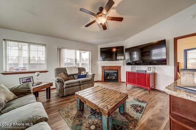 living room with ceiling fan, lofted ceiling, and hardwood / wood-style flooring