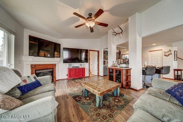 living room featuring vaulted ceiling, ceiling fan, and light hardwood / wood-style flooring