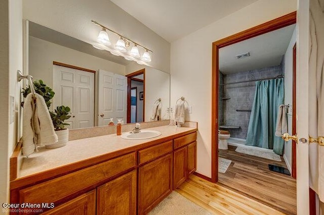 bathroom featuring toilet, vanity, a shower with curtain, and hardwood / wood-style floors