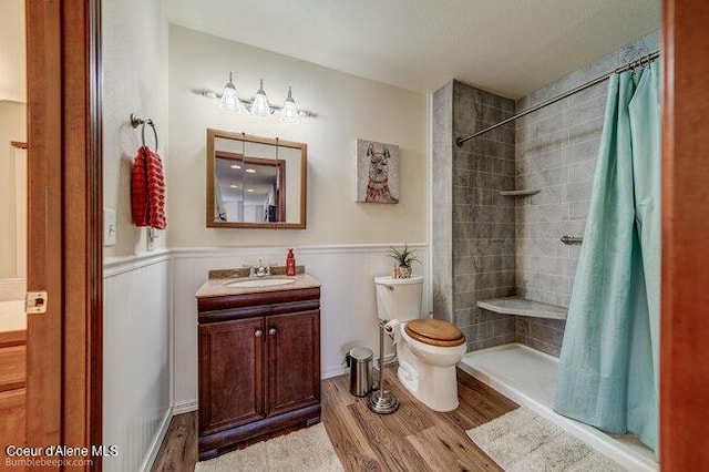 bathroom with hardwood / wood-style flooring, toilet, vanity, and a shower with curtain