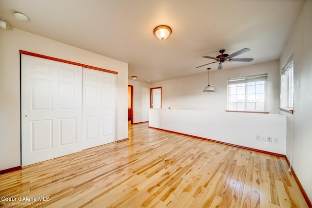 unfurnished bedroom featuring a closet, hardwood / wood-style flooring, and ceiling fan