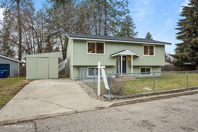 split foyer home featuring a front lawn and an outbuilding