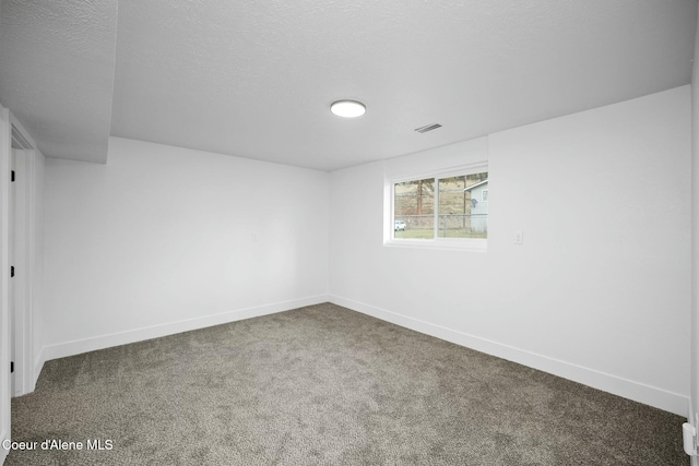 spare room with carpet and a textured ceiling