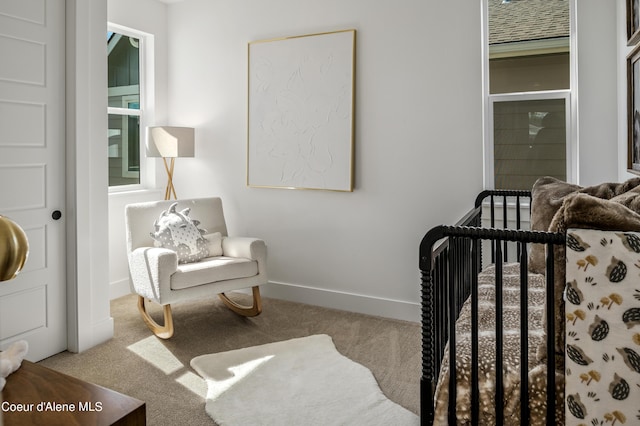 carpeted bedroom featuring a nursery area