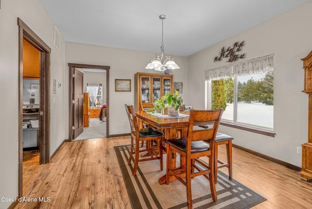 dining space featuring a chandelier and light hardwood / wood-style floors