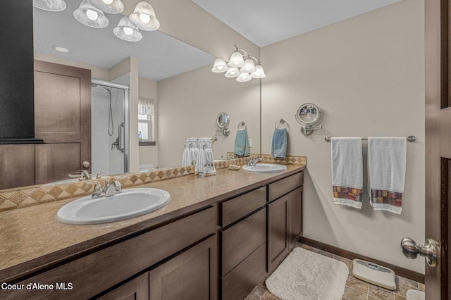 bathroom with tile patterned floors, vanity, toilet, and a shower with door