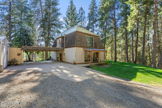 view of side of home featuring a carport and a yard