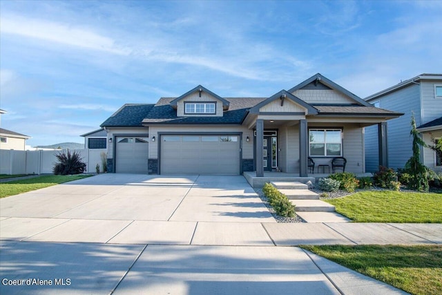 view of front of home featuring covered porch, a garage, and a front lawn