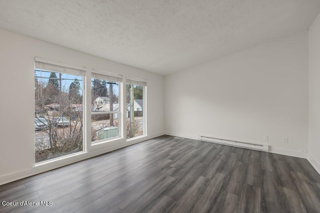 spare room with a baseboard radiator, dark hardwood / wood-style floors, and a textured ceiling