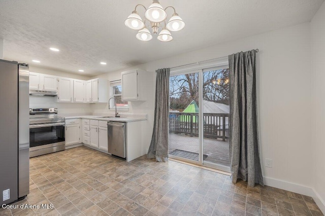 kitchen featuring white cabinetry, sink, stainless steel appliances, and a barn door