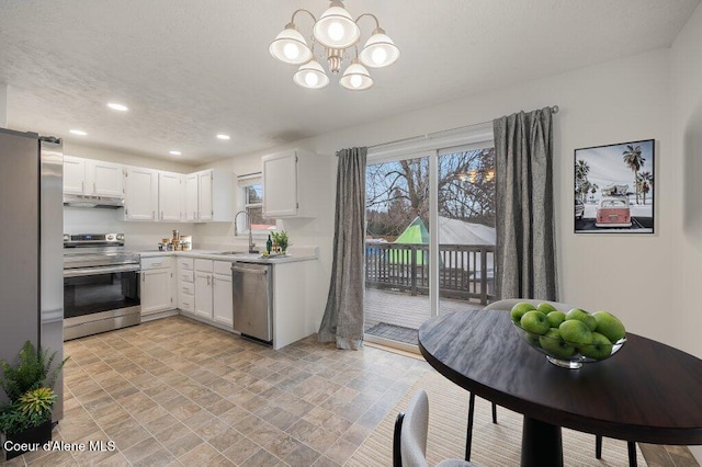 kitchen featuring sink, a notable chandelier, stainless steel appliances, and white cabinets