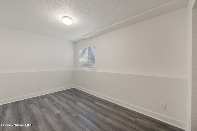 spare room with dark hardwood / wood-style flooring and a textured ceiling