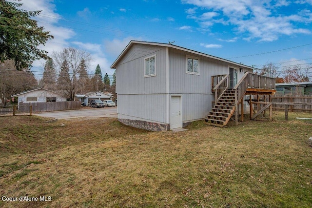 back of house featuring a wooden deck and a yard