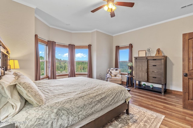 bedroom with ceiling fan, ornamental molding, and light hardwood / wood-style floors