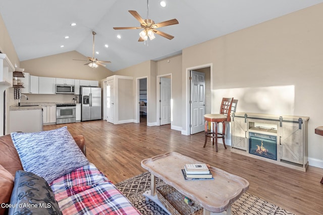 living room featuring high vaulted ceiling, sink, dark hardwood / wood-style flooring, and ceiling fan