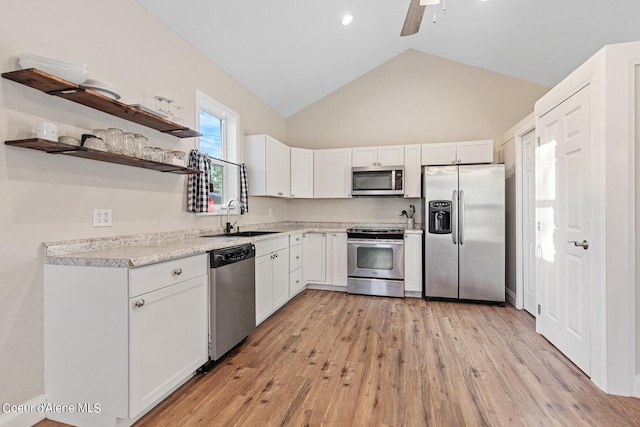 kitchen featuring light hardwood / wood-style floors, sink, white cabinetry, appliances with stainless steel finishes, and high vaulted ceiling