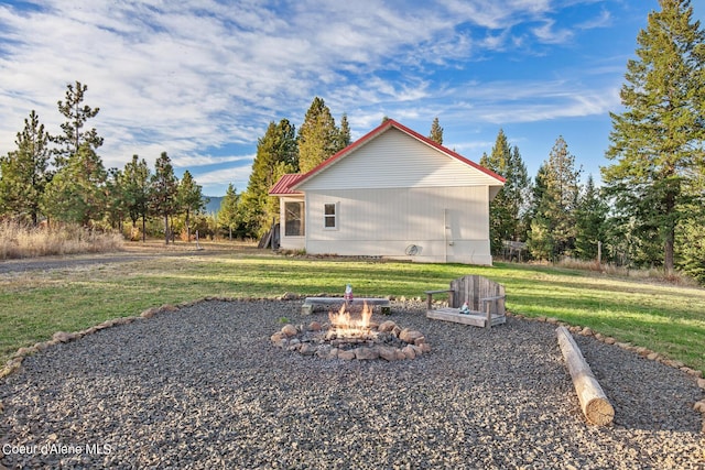 exterior space featuring a lawn and a fire pit