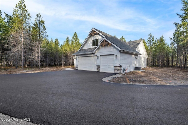 exterior space with central AC unit and a garage