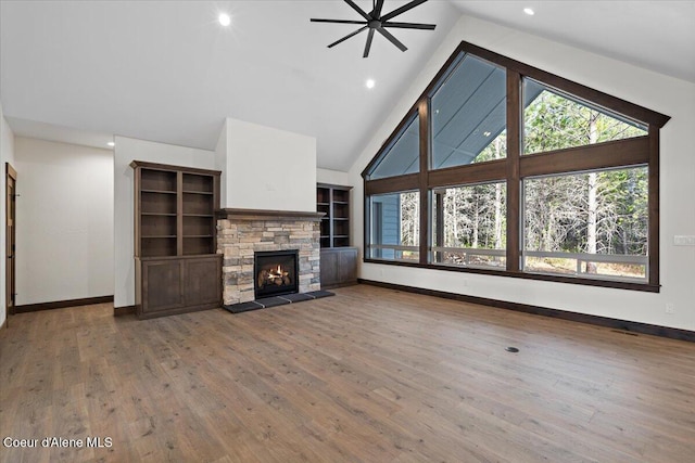 unfurnished living room with a fireplace, plenty of natural light, and vaulted ceiling