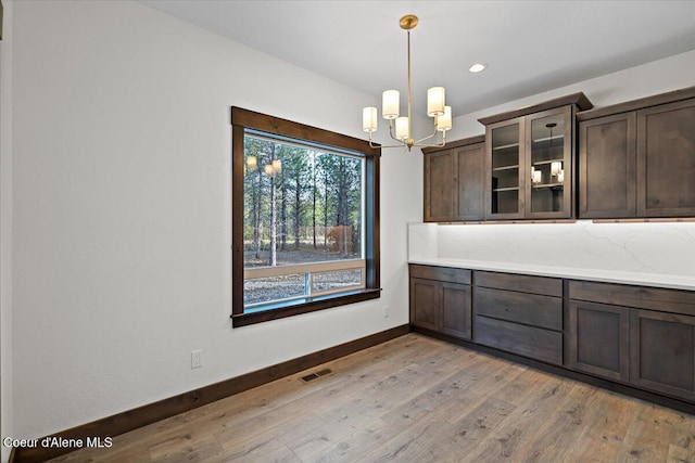 unfurnished dining area featuring light hardwood / wood-style floors and a notable chandelier