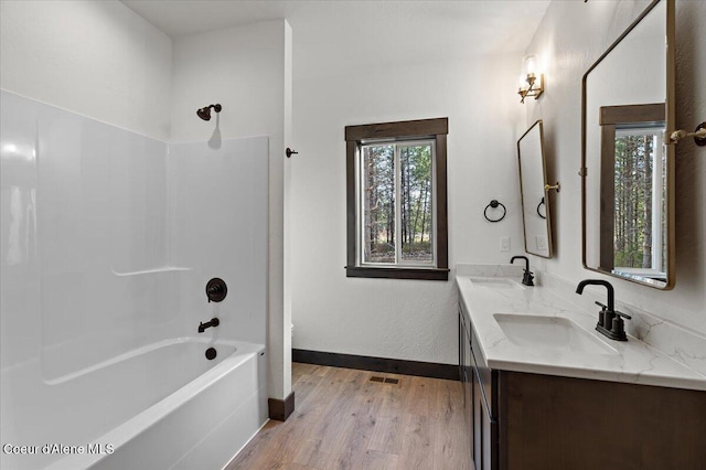 bathroom featuring hardwood / wood-style flooring, shower / tub combination, and vanity