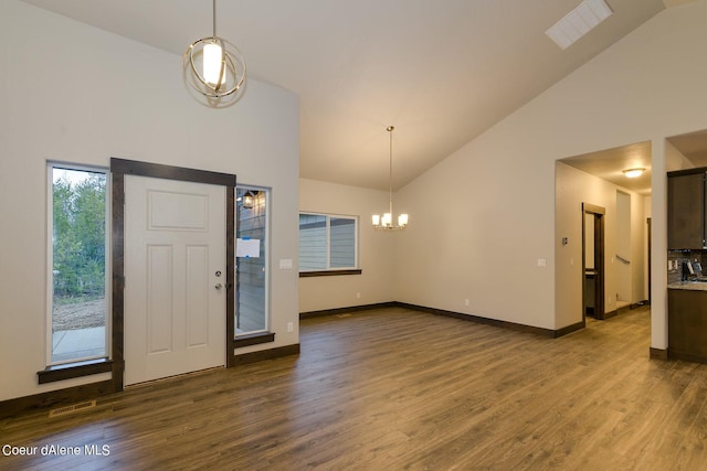 foyer with high vaulted ceiling, dark hardwood / wood-style flooring, and an inviting chandelier