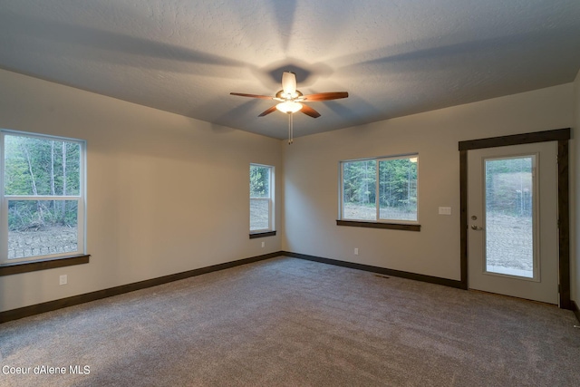 unfurnished room with ceiling fan, a textured ceiling, and carpet flooring