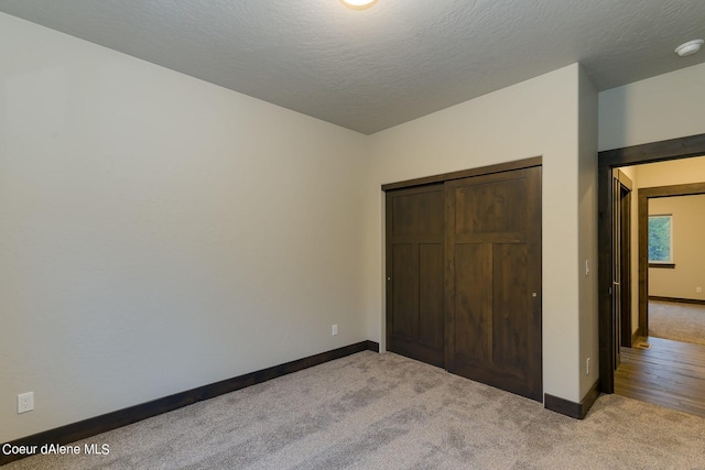 unfurnished bedroom featuring carpet, a closet, and a textured ceiling