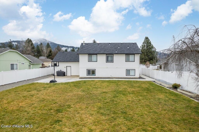 rear view of property with a patio, a mountain view, and a yard