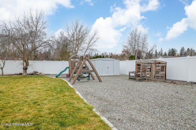 view of yard featuring a storage unit and a playground