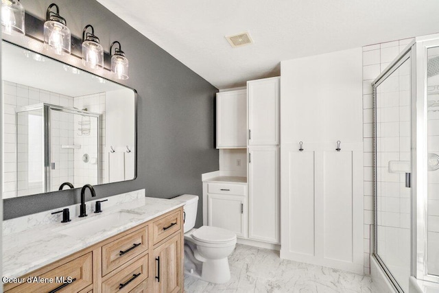 bathroom with vanity, an enclosed shower, and toilet