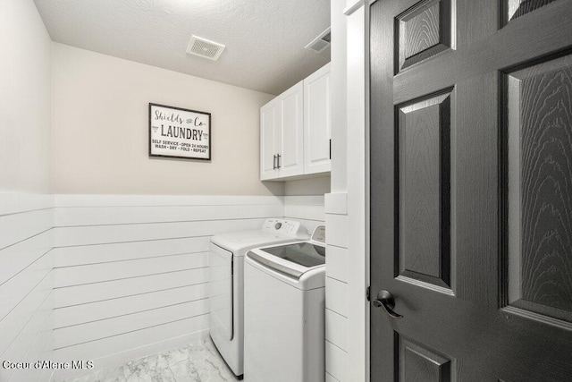 laundry area featuring cabinets, independent washer and dryer, and a textured ceiling