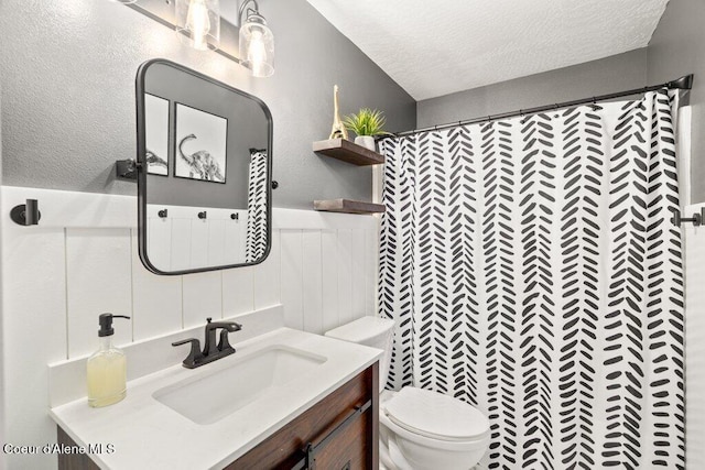 bathroom featuring vanity, toilet, a shower with shower curtain, and a textured ceiling