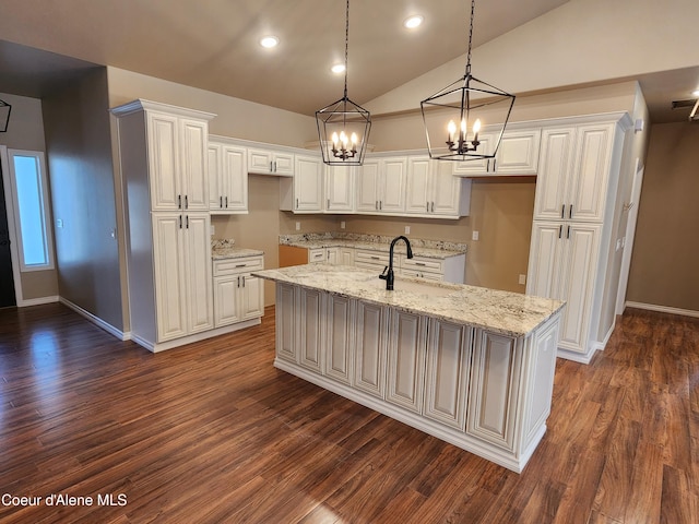 kitchen with sink, white cabinetry, lofted ceiling, and an island with sink