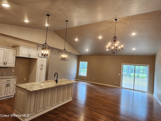 kitchen with plenty of natural light, pendant lighting, and a center island with sink